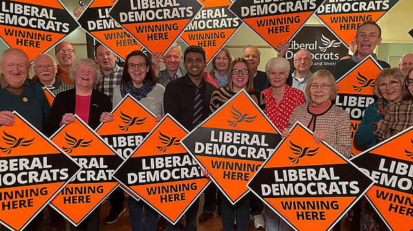 Telford & Wrekin Lib Dem members holding diamond signs stating "Liberal Democrats Winning Here"