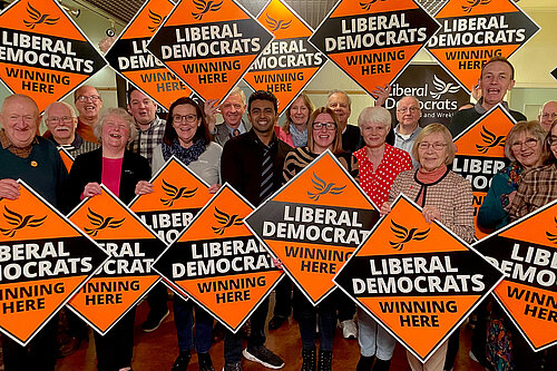 Telford & Wrekin Liberal Democrat members holding orange diamond signs declaring "Liberal Democrats Winning Here"