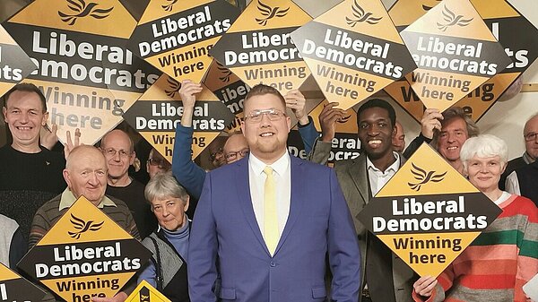 Telford and Wrekin Liberal Democrats team gathered together with diamond-shaped signs saying "Liberal Democrats Winning Here!"
