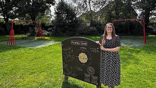 Cllr Sarah Syrda stands by an activity board in the play park